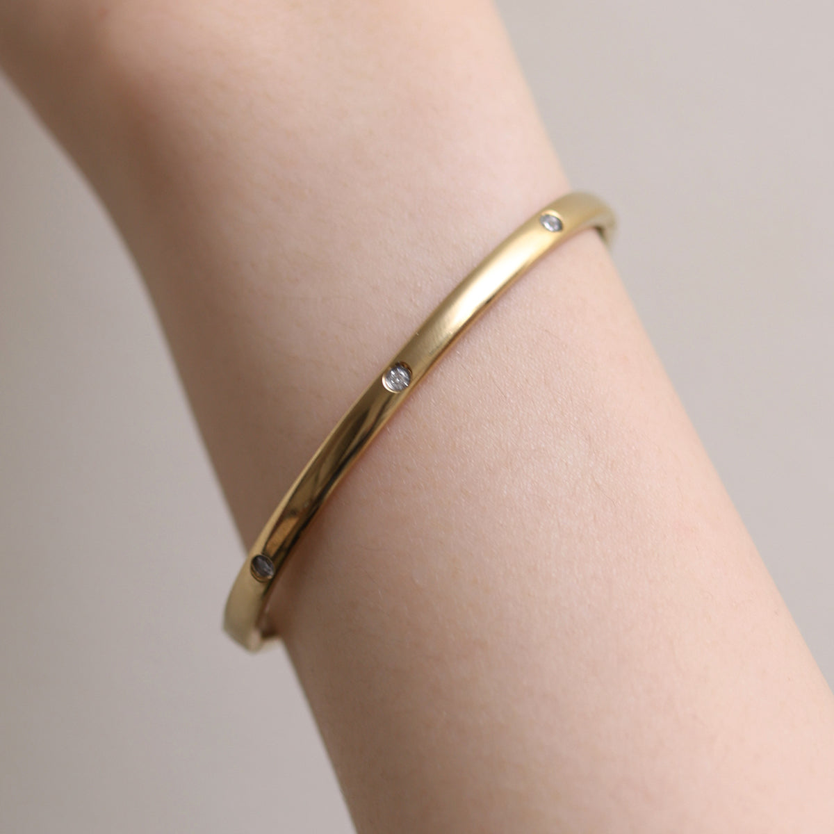 Thin Cubic Bangle precision-crafted with cubic design elements, offering a minimalist aesthetic, lightweight comfort, and versatile elegance for standalone wear or stylish layering.