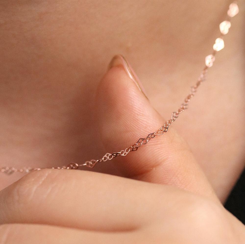 Charming Relay hearts necklace with interconnected heart-shaped links, featuring a delicate design and polished finish.