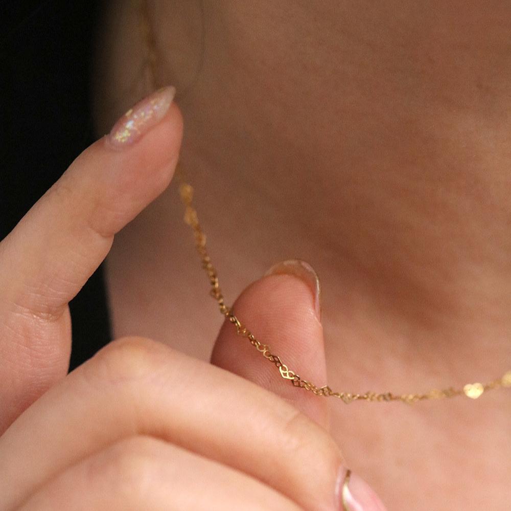 Charming Relay hearts necklace with interconnected heart-shaped links, featuring a delicate design and polished finish.